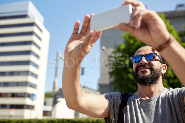 man taking video or selfie by smartphone in city Stock photo © dolgachov