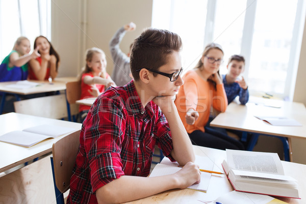 classmates laughing at student boy in school Stock photo © dolgachov