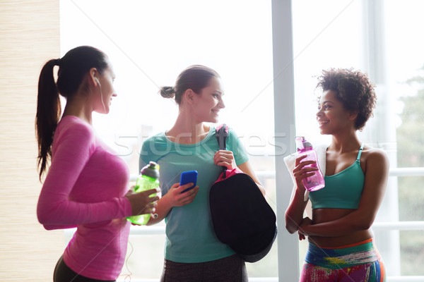happy women with bottles of water in gym Stock photo © dolgachov