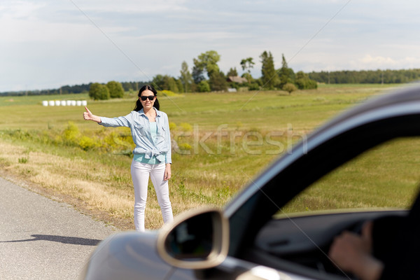 woman hitchhiking and stopping car at countryside Stock photo © dolgachov