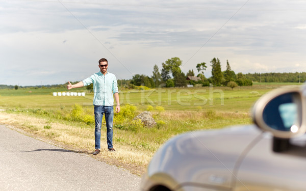 man hitchhiking and stopping car at countryside Stock photo © dolgachov