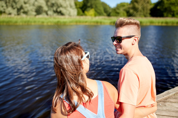 happy teenage couple sitting on river berth Stock photo © dolgachov