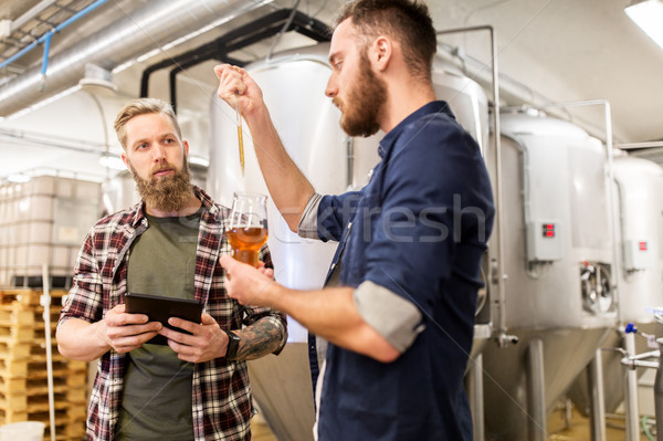 men with pipette testing craft beer at brewery Stock photo © dolgachov
