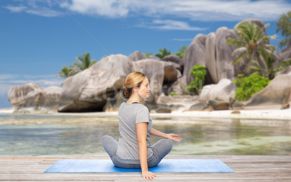 woman doing yoga in twist pose on beach Stock photo © dolgachov
