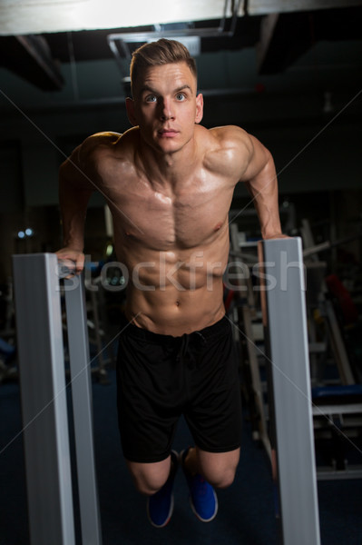 Homem tricípite molho paralelo barras ginásio Foto stock © dolgachov