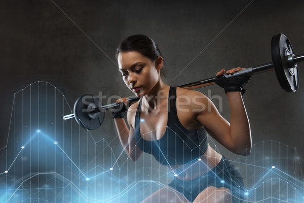 young woman flexing muscles with barbell in gym Stock photo © dolgachov