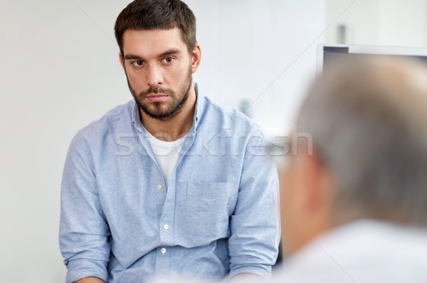 Stock photo: young male patient talking to doctor at hospital