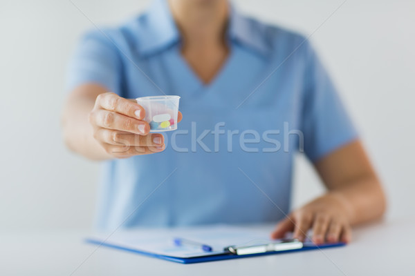 Stock photo: close up of doctor with pills in medical cup