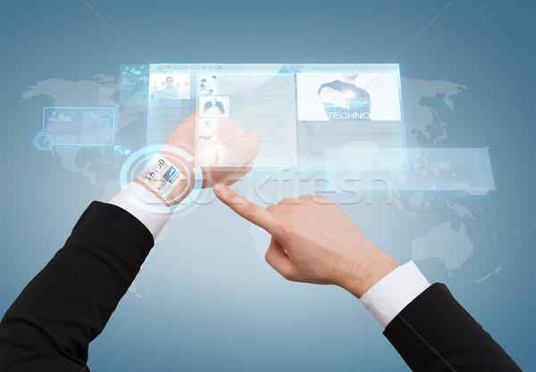 businessman pointing to virtual watch at his hand Stock photo © dolgachov