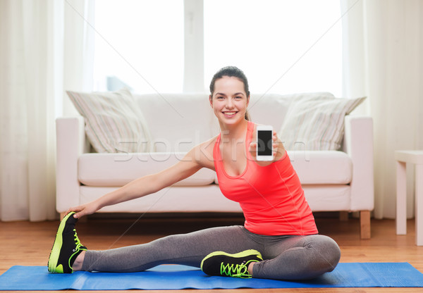 smiling teenage girl streching on floor at home Stock photo © dolgachov