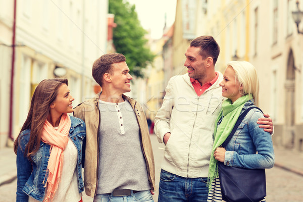 group of smiling friends walking in the city Stock photo © dolgachov