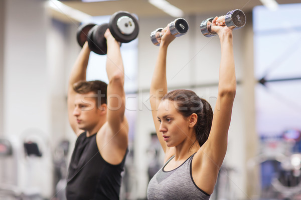 Souriant homme femme haltères gymnase sport [[stock_photo]] © dolgachov