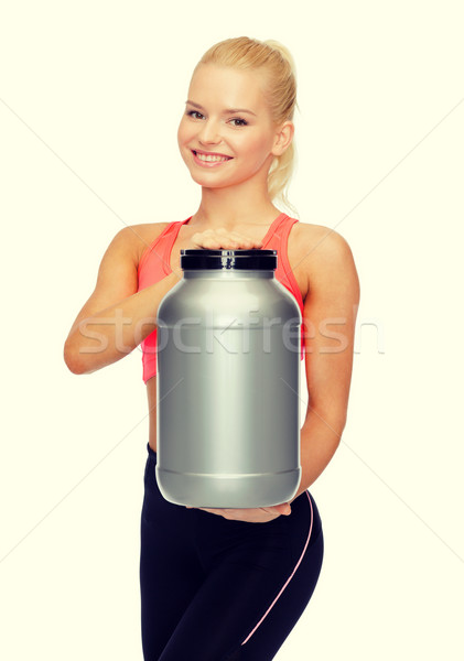 smiling sporty woman with jar of protein Stock photo © dolgachov