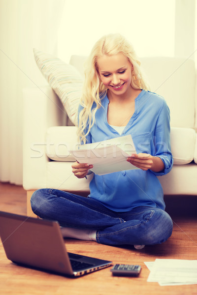 Stock photo: smiling woman with papers, laptop and calculator