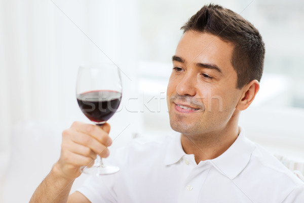 happy man drinking red wine from glass at home Stock photo © dolgachov