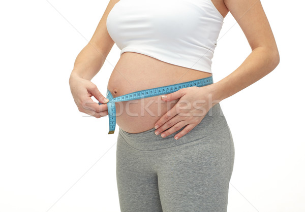 close up of pregnant woman measuring her tummy Stock photo © dolgachov