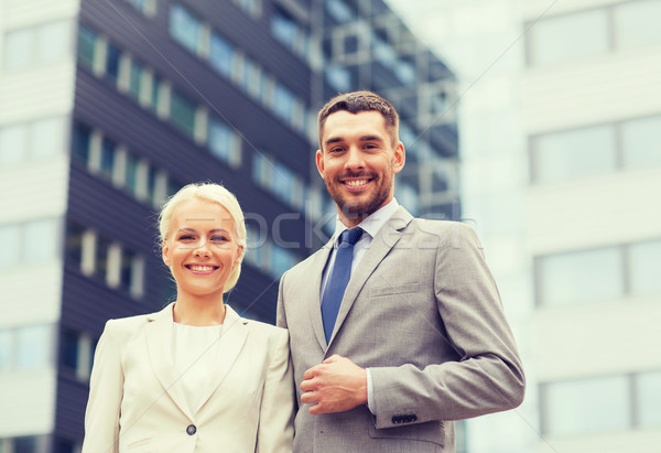 Zâmbitor oameni de afaceri în picioare cladire de birouri afaceri Imagine de stoc © dolgachov