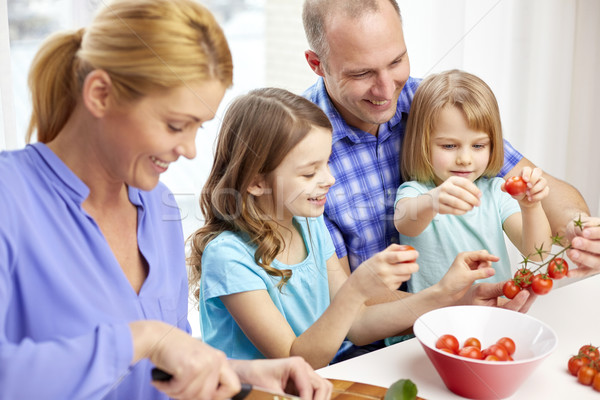 happy family with two kids cooking at home Stock photo © dolgachov
