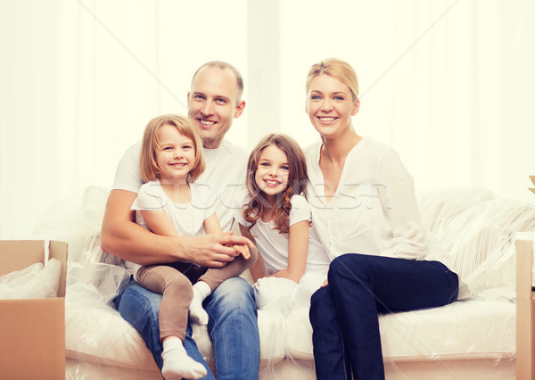 Sonriendo padres dos niñas nuevo hogar familia Foto stock © dolgachov