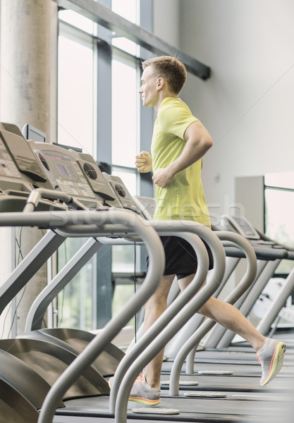 Stock photo: smiling man exercising on treadmill in gym