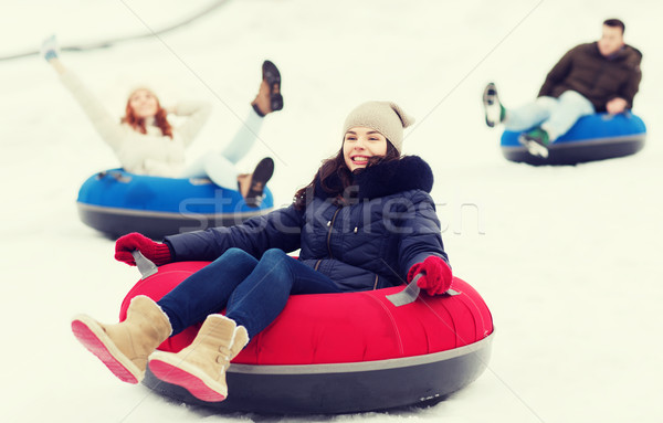 group of happy friends sliding down on snow tubes Stock photo © dolgachov