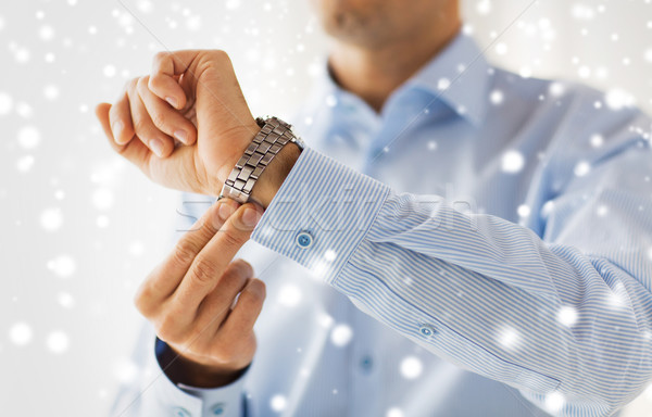 close up of man in shirt fastening wristwatch Stock photo © dolgachov