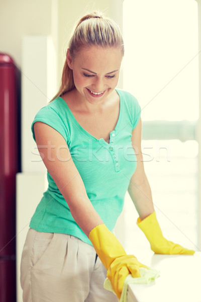 Stock photo: happy woman cleaning table at home kitchen
