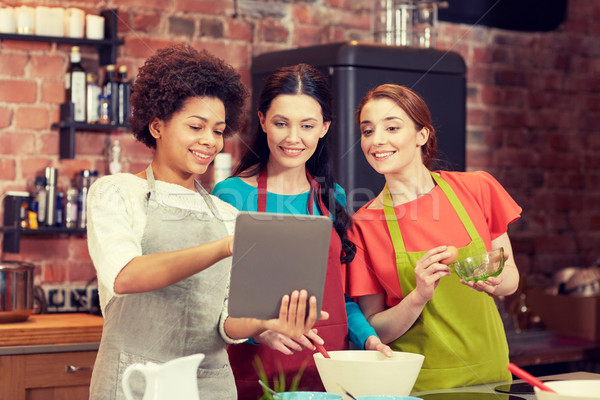 happy women with tablet pc cooking in kitchen Stock photo © dolgachov