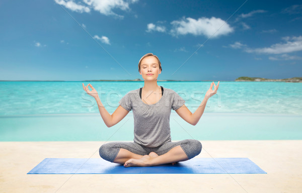 woman making yoga meditation in lotus pose on mat Stock photo © dolgachov