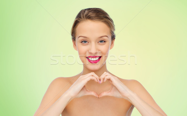 Souriant jeune femme forme de coeur signe de la main beauté Photo stock © dolgachov