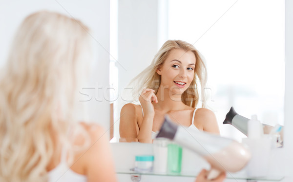 happy young woman with fan drying hair at bathroom Stock photo © dolgachov