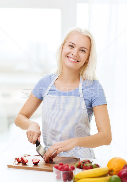 smiling young woman chopping fruits at home Stock photo © dolgachov
