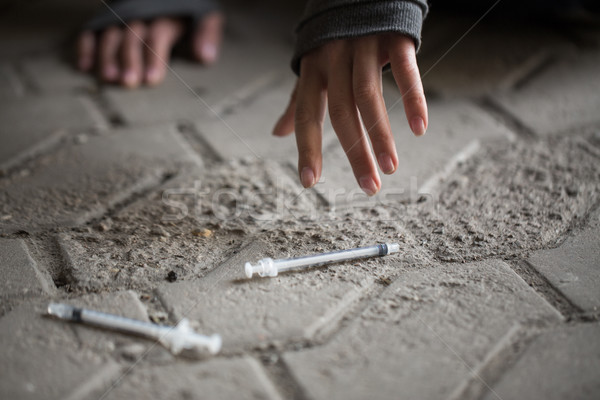 Stock photo: close up of addict woman hands and drug syringes