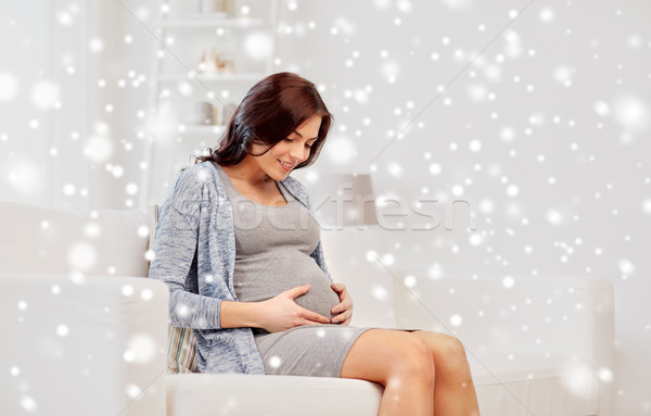happy pregnant woman sitting on sofa at home Stock photo © dolgachov