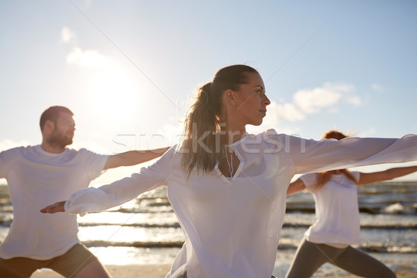 group of people making yoga exercises on beach Stock photo © dolgachov