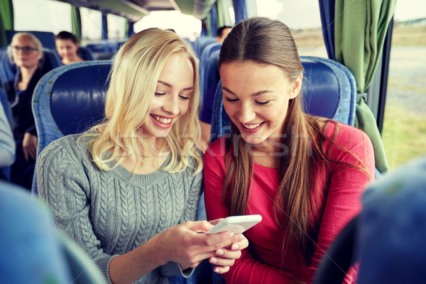happy young women in travel bus with smartphone Stock photo © dolgachov