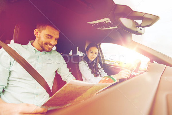 happy man and woman with road map driving in car Stock photo © dolgachov