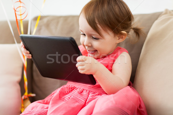 baby girl with tablet pc at home Stock photo © dolgachov