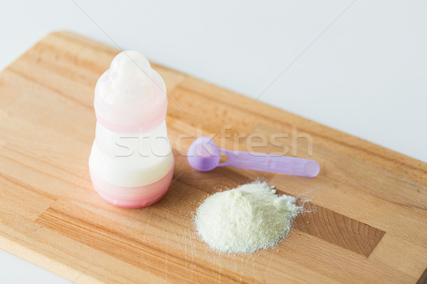 infant formula, baby bottle and scoop on board Stock photo © dolgachov