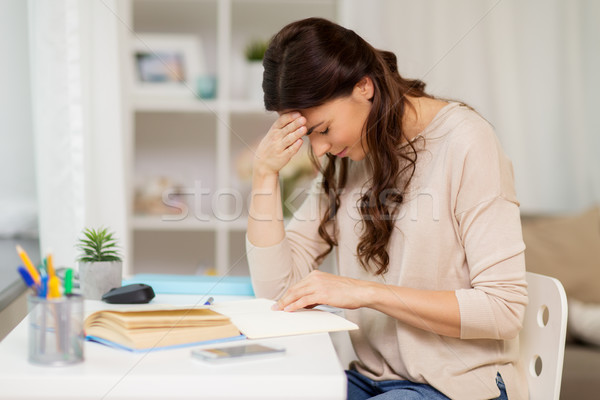 tired female student with book learning at home Stock photo © dolgachov