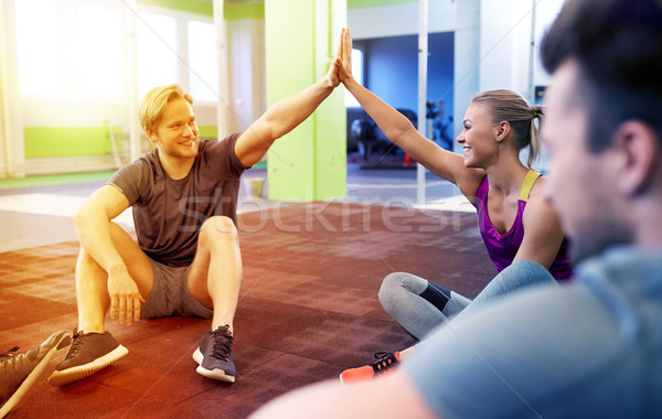 group of happy friends making high five in gym Stock photo © dolgachov