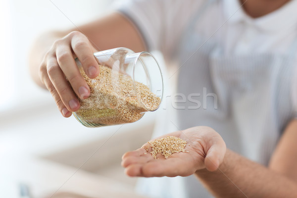 close up of male emptying jar with quinoa Stock photo © dolgachov
