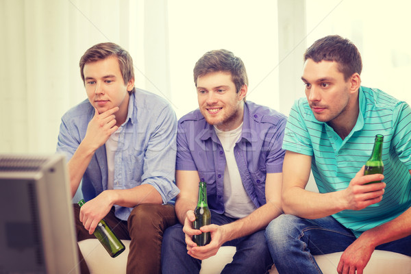 Mutlu erkek arkadaşlar bira izlerken tv Stok fotoğraf © dolgachov