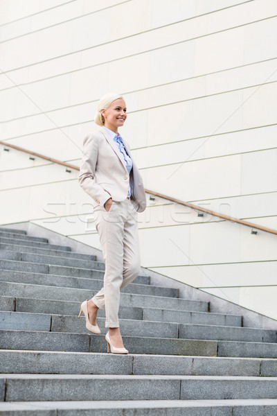 young smiling businesswoman walking down stairs Stock photo © dolgachov