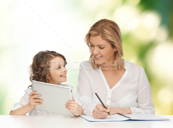 woman with notebook and girl holding tablet pc  Stock photo © dolgachov