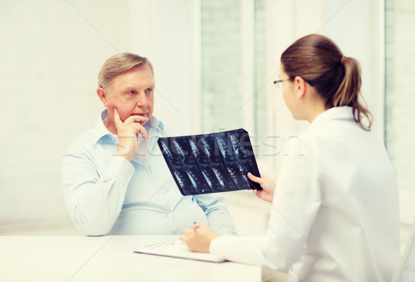 Stock photo: female doctor with old man looking at x-ray