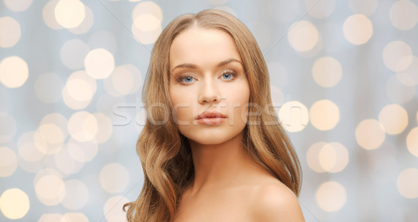 beautiful young woman face over holidays lights Stock photo © dolgachov