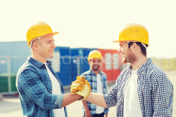 Stock photo: group of smiling builders in hardhats outdoors