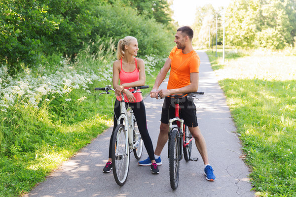 happy couple riding bicycle outdoors Stock photo © dolgachov