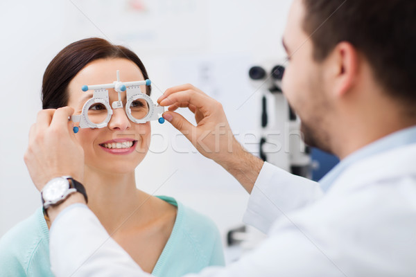 optician with trial frame and patient at clinic Stock photo © dolgachov
